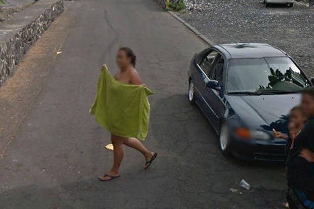 На снимке женщина выглядит только в шлепанцах и защищает свою скромность зеленым полотенцем